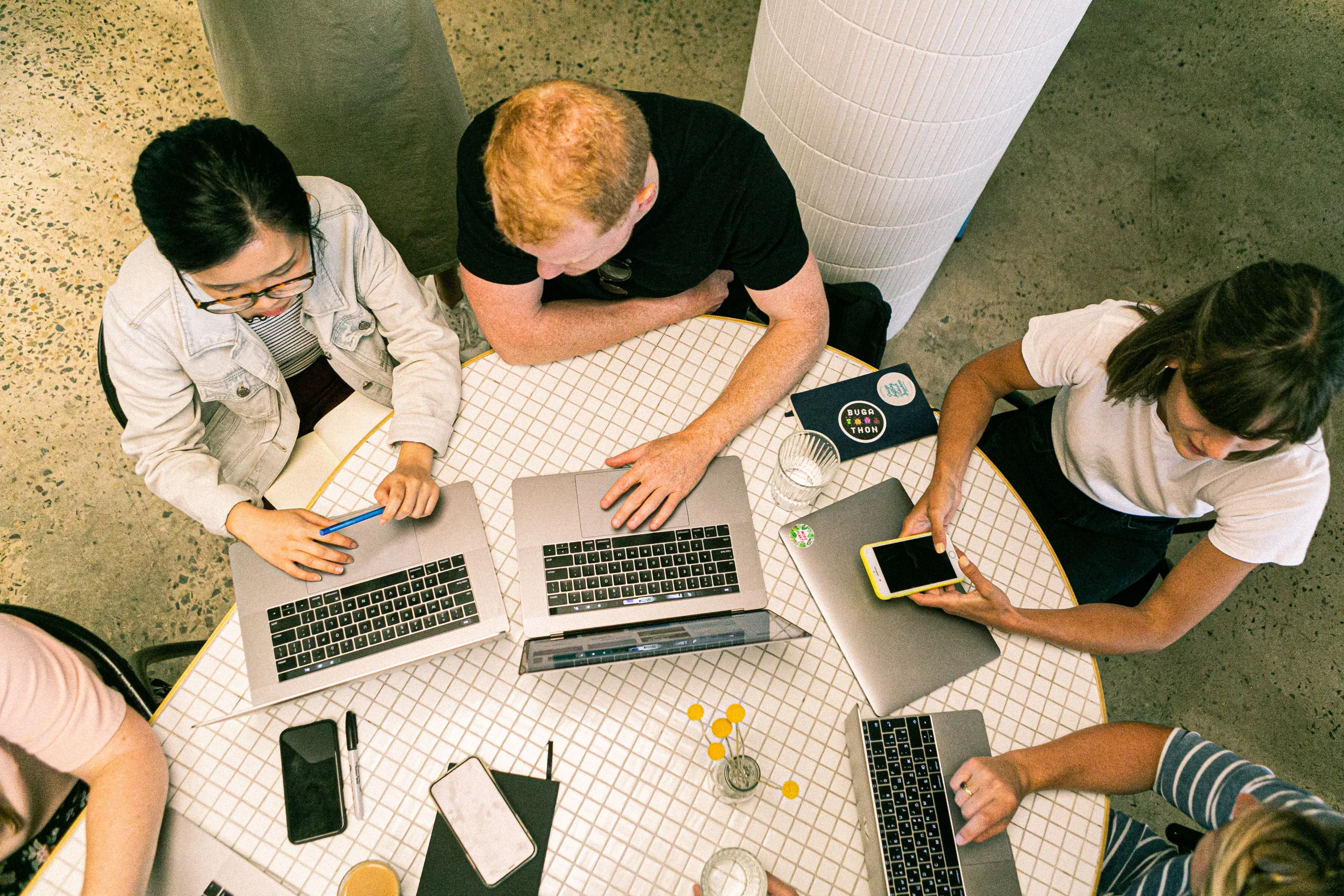 A group of people working together on laptops at the library.